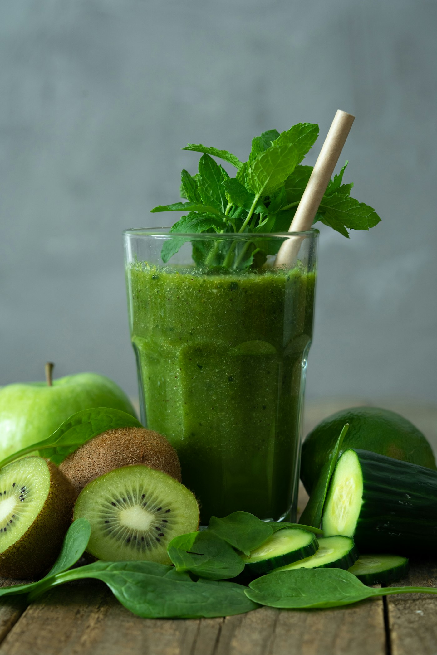 Fresh green juice surrounded by citrus and leaves