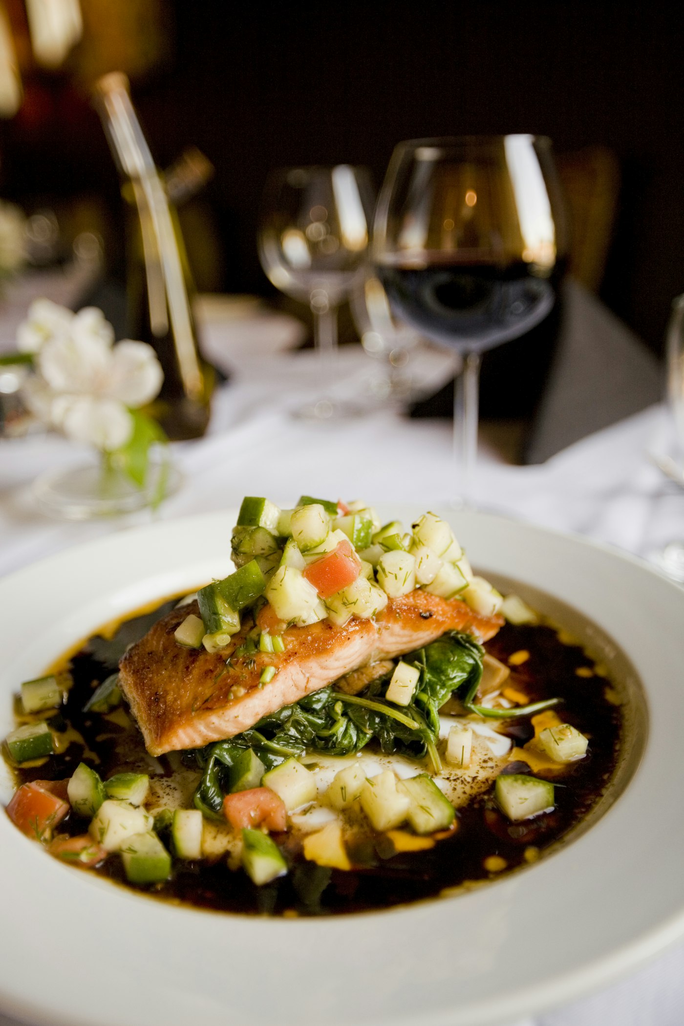 A plated piece of salmon with vegetables