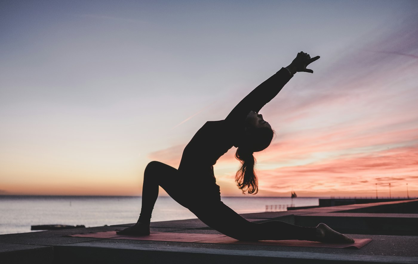 A person practicing a calm stretch in a bright room